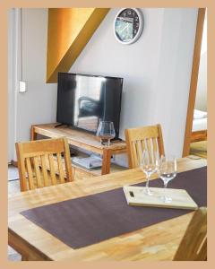 a table with two wine glasses and a television at Schwarzwaldpension Tuttlingen in Tuttlingen