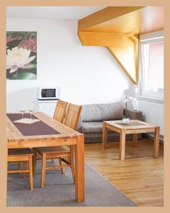 a living room with a wooden table and a couch at Schwarzwaldpension Tuttlingen in Tuttlingen