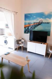 a living room with a flat screen tv on a white cabinet at Quiet loft studio - Pinel side in Cul de Sac