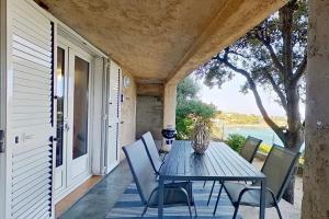 a table and chairs on the porch of a house at Résidences Sopramare in Algajola