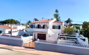 a large white house with a fence at Santa Brígida in Cala en Porter