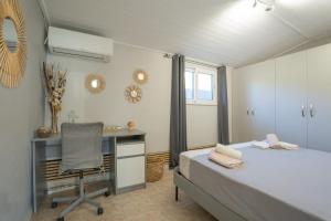 a bedroom with a desk and a bed and a chair at Cuervo Poolside Villa in Kalívia Thorikoú +44 photos