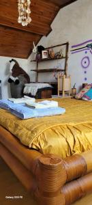 a bedroom with a large bed with yellow sheets at Le Grenier d'Artiste in Laguépie