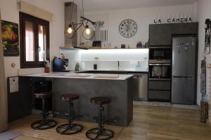 a kitchen with a counter and stools in it at La Cambra casa rural Premium in Potríes