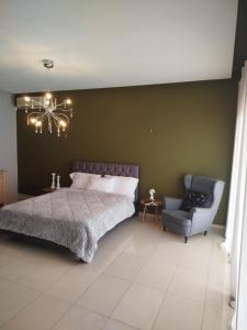 a bedroom with a bed and a chair at Grace, fifteen minutes drive away from the beach in Kolymvari