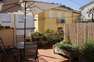 a patio with an umbrella and a table and chairs at La Cambra casa rural Premium in Potríes