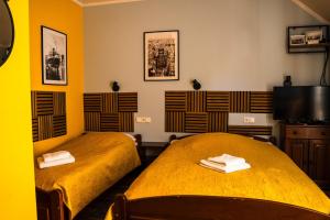 two beds in a room with yellow walls at Willa Bliska in Gdańsk