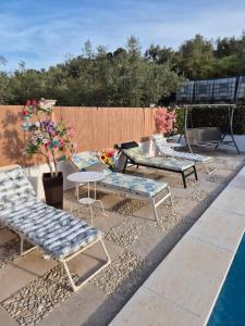 a patio with chairs and a table and a pool at beautiful guest room with swimming pool in Gormach