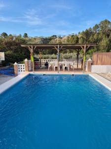 a swimming pool with a gazebo and a table at beautiful guest room with swimming pool in Gormach