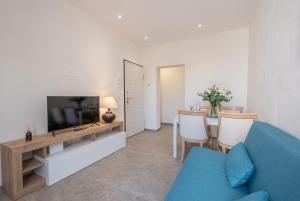 a living room with a blue couch and a television at LORENZO APPARTAMENTO Borgo Giannotti in Lucca