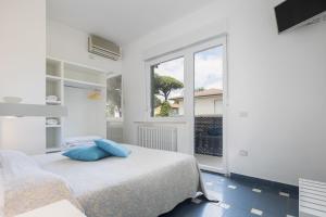 a white bedroom with a bed and a window at CASA MAJOR Hotel & Appartamenti CERVIA in Cervia