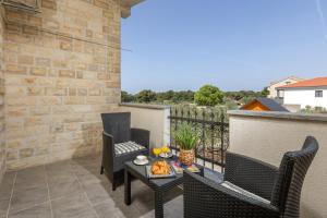 a balcony with chairs and a table with food on it at Peacefull Apartment with Garden and Barbeque in Biograd na Moru