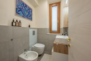 a bathroom with a white toilet and a sink at LORENZO APPARTAMENTO Borgo Giannotti in Lucca +16 photos