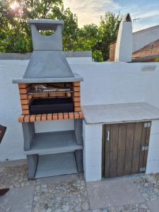 a outdoor grill with a wood stove on a patio at beautiful guest room with swimming pool in Gormach