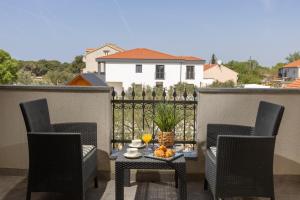 a patio with chairs and a table with a bowl of fruit at Peacefull Apartment with Garden and Barbeque in Biograd na Moru +50 photos