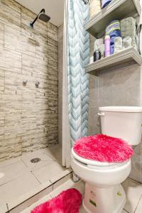 a bathroom with a toilet with a pink lid at Caribbean apartment in private area in Cancún +13 photos