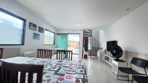 a dining room with a table and chairs and a living room at Casa em Gravatá com piscina privativa por Yolo in Gravatá