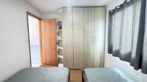 a bedroom with two beds and a closet and a window at Casa em Gravatá com piscina privativa por Yolo in Gravatá +23 photos