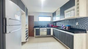 a kitchen with a refrigerator and a counter top at Casa em Gravatá com piscina privativa por Yolo in Gravatá