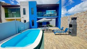 a blue house with a swimming pool and a patio at Casa em Gravatá com piscina privativa por Yolo in Gravatá