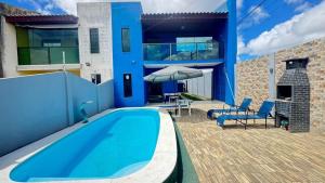 a blue house with a swimming pool on a patio at Casa em Gravatá com piscina privativa por Yolo in Gravatá