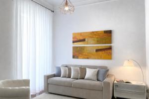 a living room with a couch and a painting at VILLA EUGENIA - Luxury Flat in the Centre, with Parking Space in Bordighera +16 photos