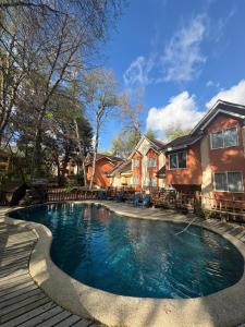 a swimming pool in front of a house at Hotel y Cabañas Borde Andino in Las Trancas