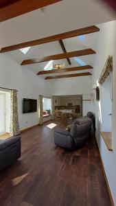 a living room with couches and a dining room at Cottages Lyndale Farm in Flashader
