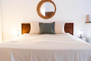 a bedroom with a white bed with a mirror on the wall at Quiet loft studio - Pinel side in Cul de Sac +13 photos