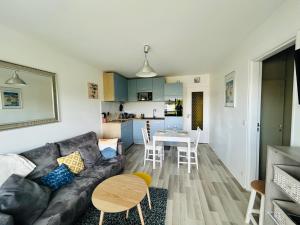 a living room with a couch and a table at La case du trimaran in Cabourg