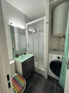 a bathroom with a sink and a washing machine at La case du trimaran in Cabourg +10 photos