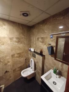 a bathroom with a toilet and a sink at Darshana Studios#Cozy in Noida