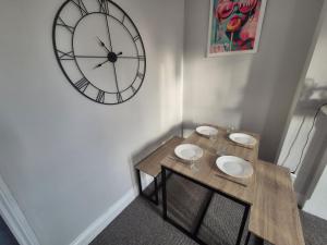 a small table with a large clock on the wall at Castle View Dover in Dover +1 photo