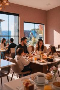 a group of people sitting at tables in a restaurant at Villa Belle Chalés in Campos do Jordão +83 photos