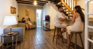 a man and woman sitting at a bar in a living room at Villa Belle Chalés in Campos do Jordão