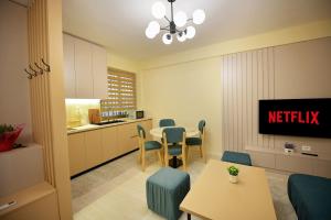 a living room with a table and chairs and a kitchen at Dedi Apartment 1 in Shkodër