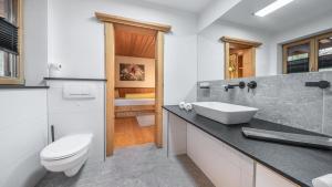 a bathroom with a white toilet and a sink at Landhaus Am Arzbach in Bad Tölz +139 photos