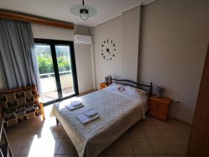 a bedroom with a bed and a clock on the wall at Studio Apartments Eirini in Pyrgi Thermis