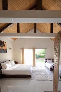 a bedroom with a large bed and a large window at Mahafaly Hotel & Resort in Antsirabe