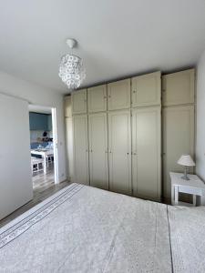 a bedroom with white cabinets and a chandelier at La case du trimaran in Cabourg