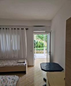 a room with two beds and a sliding glass door at Renato Rooms & Apartments in Vlorë