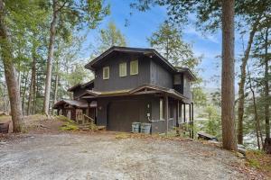 a house on top of a hill in the woods at Beebe Lake House in Castleton