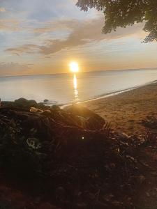 a sunset on the beach with the sun setting over the water at sandbar Homestay in Lautoka +2 photos