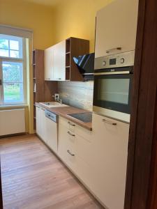 a kitchen with white cabinets and a stove top oven at Zeilinger Villa in Knittelfeld