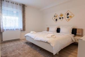 a bedroom with a large bed with white sheets at Ferienwohnung am Buttermarkt in Adenau +12 photos