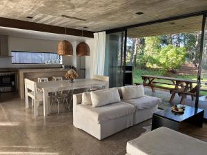 a living room with a white couch and a table at CASA HORTENSIAS in Quequén