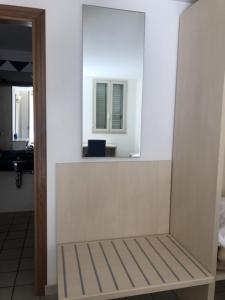 a white room with a mirror and a table at Hotel Sirenetta in Isola delle Femmine