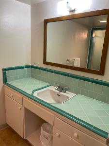 a bathroom with a sink and a mirror at Crystal Motel in Red Bluff