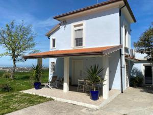 a white house with chairs and a table at Villa Gennari vista mare in Gradara