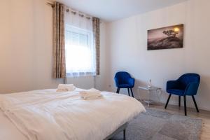 a bedroom with two blue chairs and a bed at Ferienwohnung am Buttermarkt in Adenau